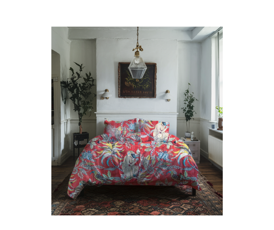 Colorful cotton Kantha blanket with monkey print displayed on bed in cozy bedroom setting