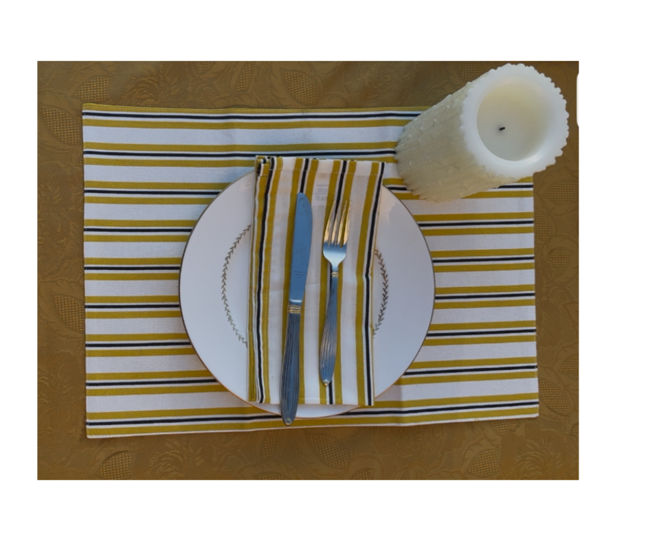 Striped cotton table linen with plate, knife, fork, napkin, and white candle on brown textured tablecloth
