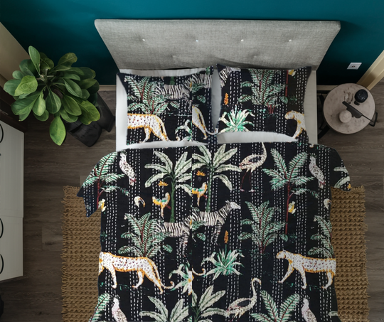 Hand-quilted Kantha blanket with safari animal print, 100% cotton voile, lightweight and reversible, styled on bed with matching pillows in modern bedroom.