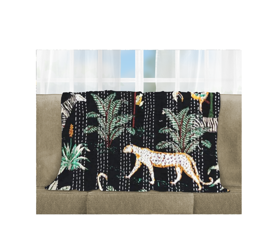 Kantha Blanket Safari with hand-stitched animal and plant patterns on black cotton voile, lightweight and quilted, draped on sofa.